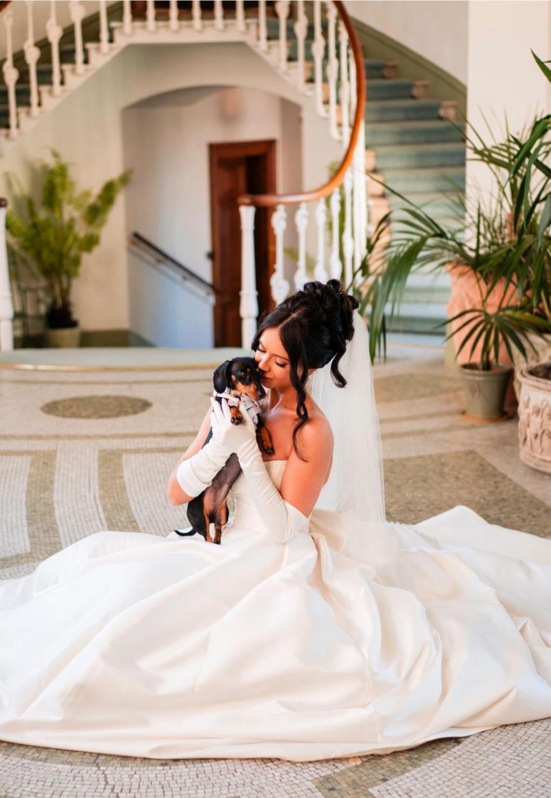 Amy in her wedding dress holding the dog